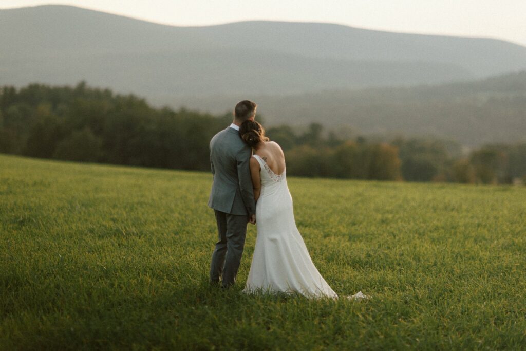 Jeunes mariés debout dans un champ le jour de leur mariage