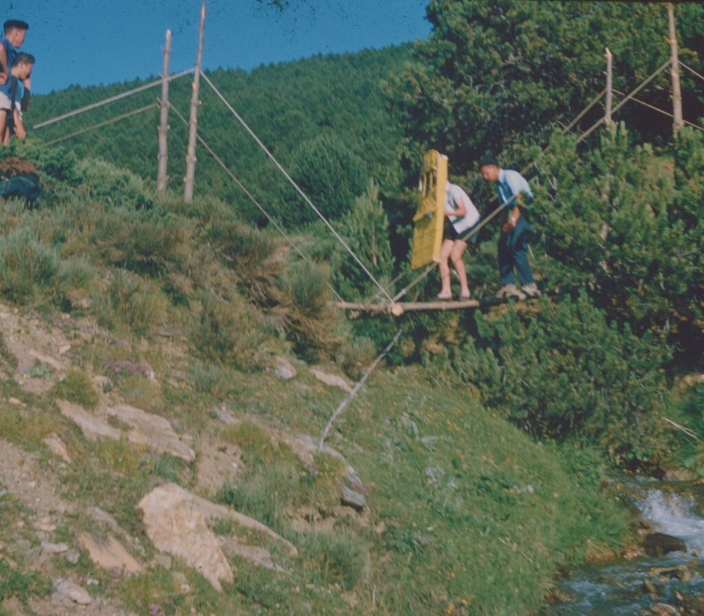 Équipe traversant un ruisseau sur un pont en bois pendant une activité en plein air